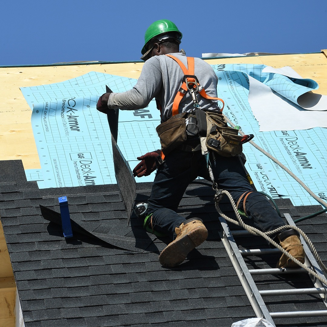 Couvreur professionnel travaillant sur une toiture à Montréal